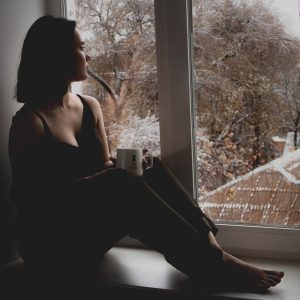 编辑部内容编辑的正面头像照片，年轻女性坐在电脑前整理资料，桌面摆着笔记本和咖啡杯，明亮自然光